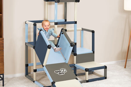 Child sliding down ramp from climbing frame